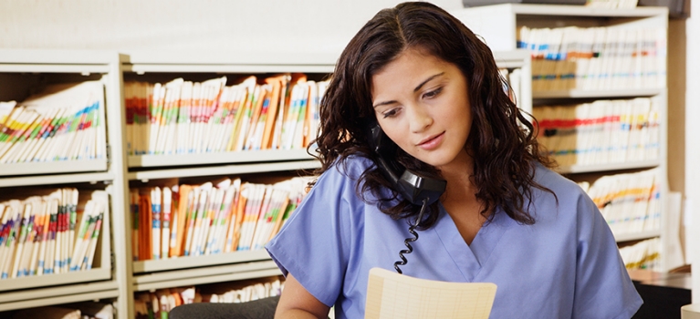 Woman in office staff on phone and holding file